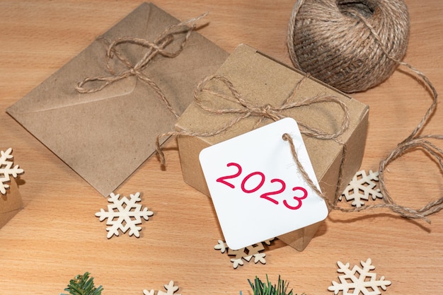 Feliz Año Nuevo 2023 Regalos hechos de papel artesanal con la etiqueta 2023 sobre la mesa