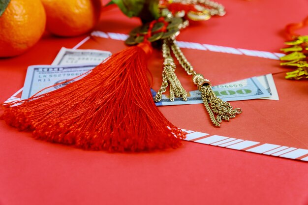 Feliz año nuevo chino dólares americanos con decoraciones tradicionales sobre fondo rojo.