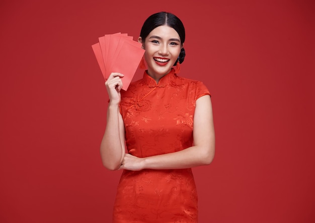 Feliz año nuevo chino mujer asiática con vestido tradicional cheongsam qipao sosteniendo angpao