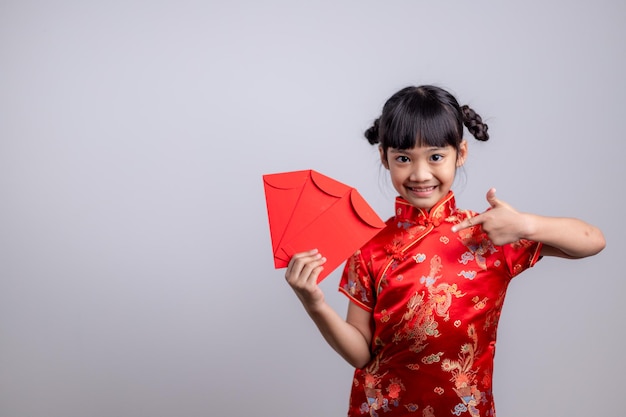 Feliz Año Nuevo Chino. Sonrientes niñas asiáticas sosteniendo un sobre rojo