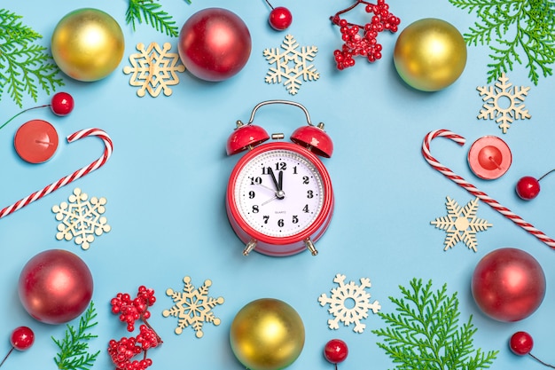 Feliz año nuevo composición laica plana, reloj decoración de Navidad sobre fondo azul