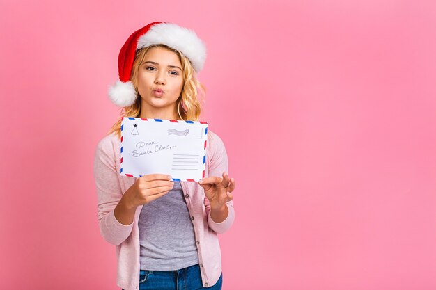 ¡Feliz año nuevo y navidad! Cute little kid adolescente chica rubia con carta a Santa