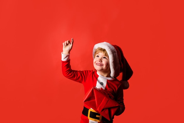 Feliz año nuevo navidad niños niño con regalo de navidad niño feliz en traje de santa poco