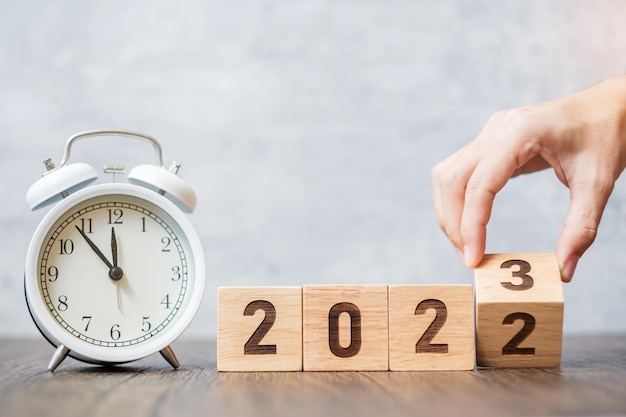 Feliz año nuevo con reloj despertador vintage y cambio de 2022 a bloque 2023 Navidad Nuevo inicio Resolución cuenta regresiva Objetivos Plan Acción y concepto de motivación