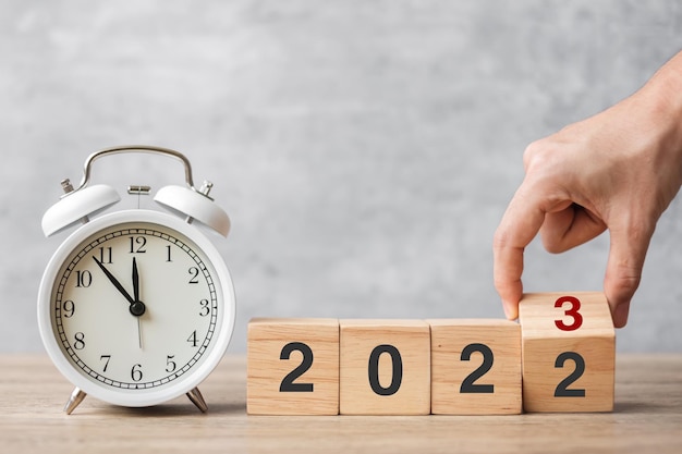 Feliz año nuevo con reloj despertador vintage y cambio de mano 2022 a bloque 2023 Navidad Nuevo inicio Resolución cuenta regresiva Objetivos Plan Acción y concepto de motivación