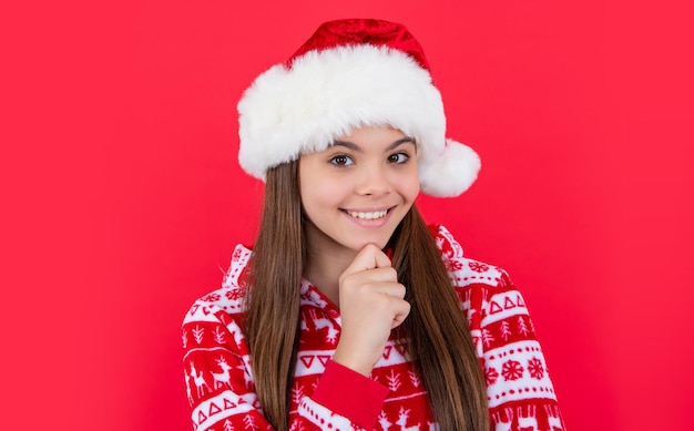 Feliz año nuevo sonriente jovencita en rojo año nuevo sombrero de santa en estudio