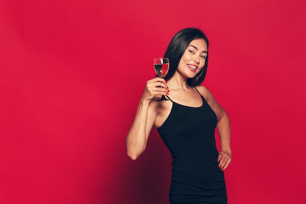 Foto feliz año nuevo para usted. una joven y bella mujer bailando con copa de champán