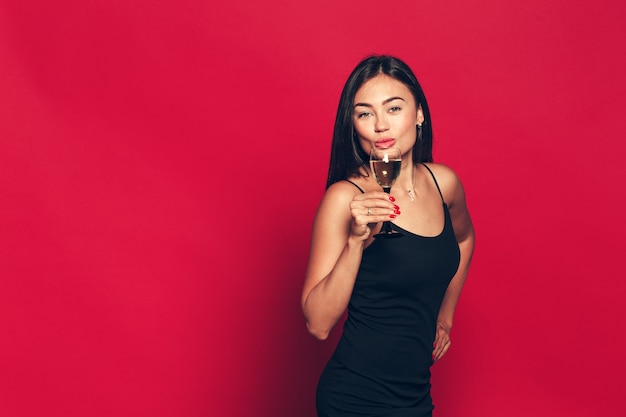 Feliz Año Nuevo para usted. Una mujer joven y hermosa bailando con copa de champán