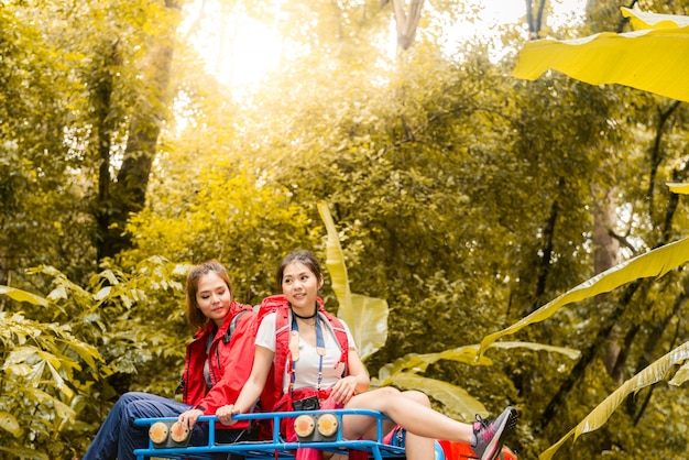 Feliz asiáticos jóvenes viajeros con 4x4 conducir coche fuera de carretera en el bosque