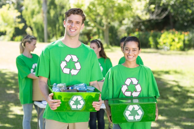 Feliz ativistas ambientais no parque com recicláveis