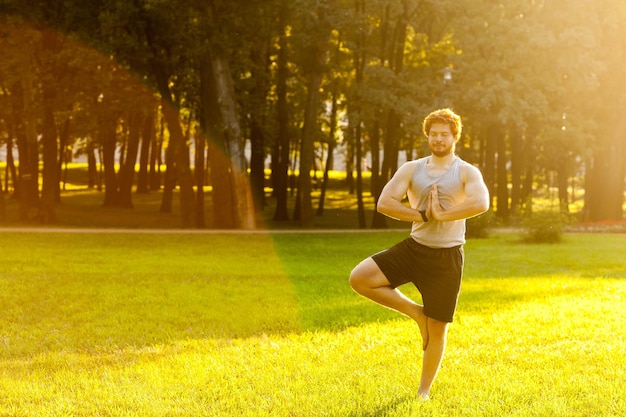 Feliz atleta barbudo haciendo yoga