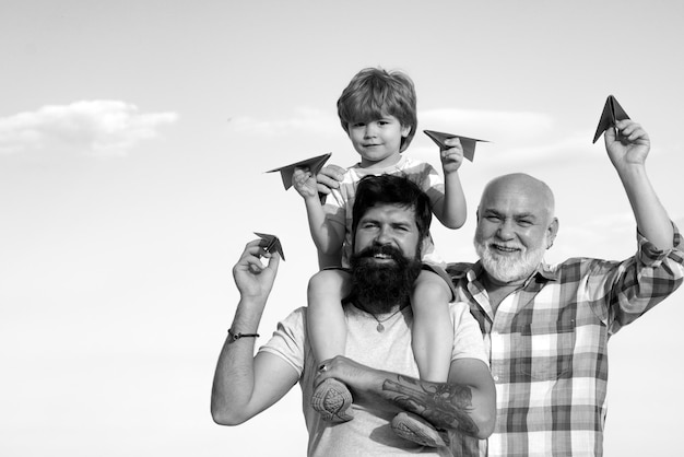 Feliz avô pai e neto com avião de papel de brinquedo sobre céu azul e nuvens fundo ha