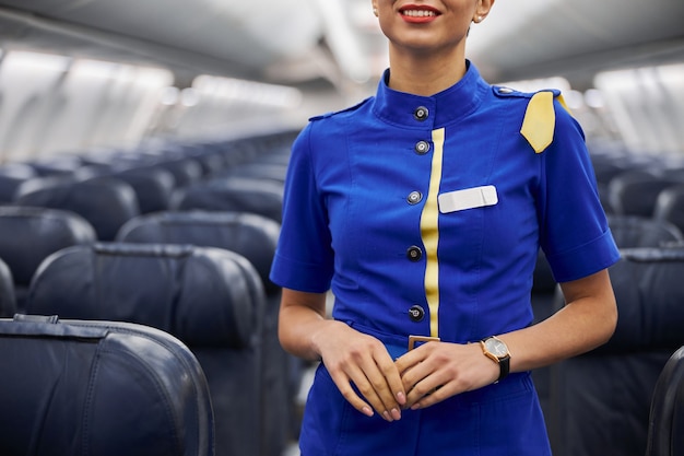 Foto feliz azafata profesional está preparando el salón antes de volar la noche