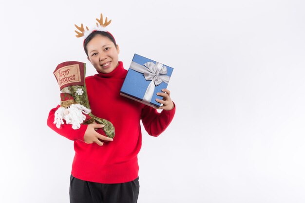 Foto feliz bastante joven sosteniendo caja de regalo sobre fondo gris