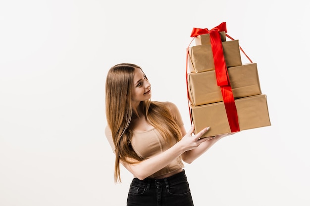 Feliz bastante joven sosteniendo cajas de regalo con presente sobre fondo blanco Celebración de eventos y recibiendo regalos en cumpleaños u otras vacaciones