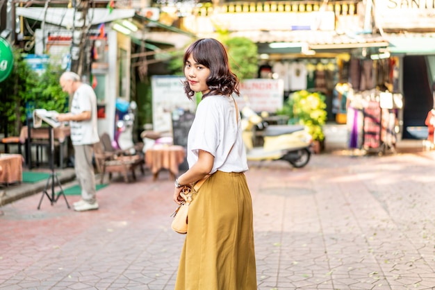 Feliz y bella mujer asiática viajando en Khao Sarn Road, Tailandia