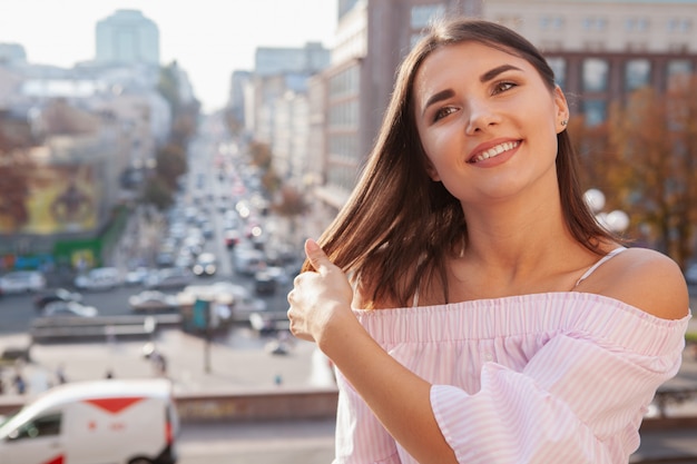 Feliz bella mujer en calles de la ciudad