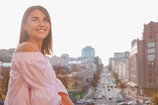 Feliz bella mujer en calles de la ciudad