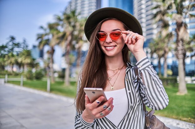 Feliz bella mujer sonriente de moda hipster al aire libre