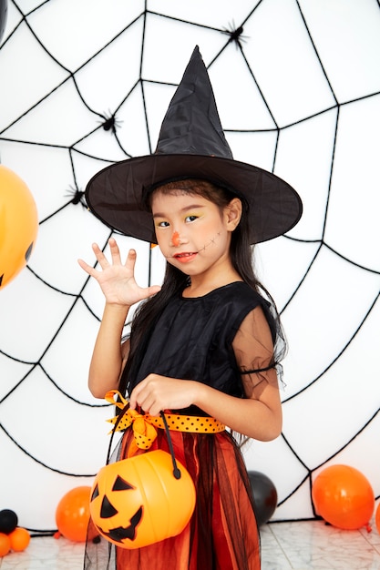 Feliz brujita de Halloween con una calabaza