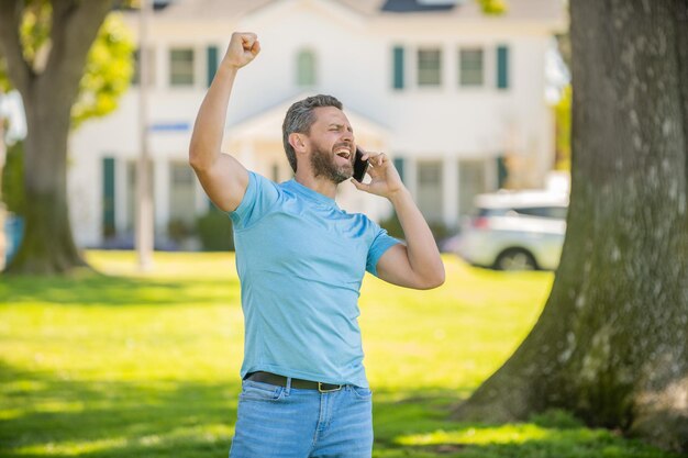 Feliz cara não barbeado falando no telefone conversa emocionalmente