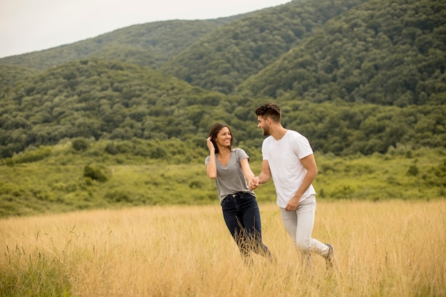 Feliz casal apaixonado andando pelo campo de grama