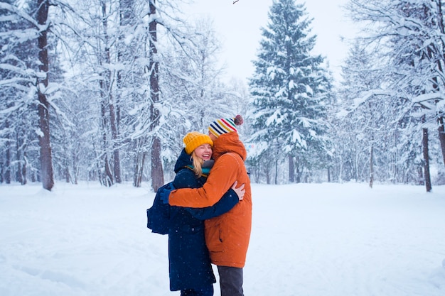 feliz casal apaixonado na floresta de inverno nevado