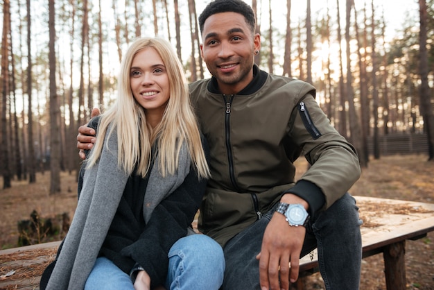 Feliz casal apaixonado sentado ao ar livre na floresta