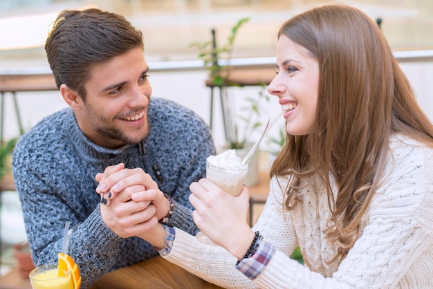 Feliz casal apaixonado sentado em um café e se comunicando