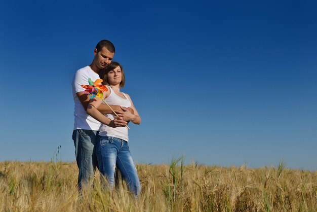 feliz casal apaixonado tem romance e diversão no campo de trigo no verão