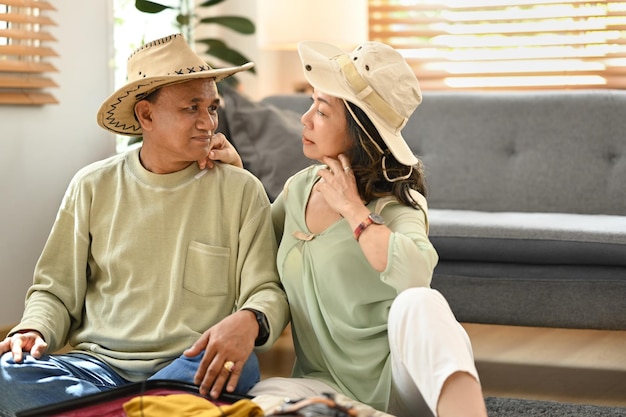 Feliz casal aposentado embalando roupas na mala de viagem se preparando para as férias de verão Viajando no conceito de aposentadoria