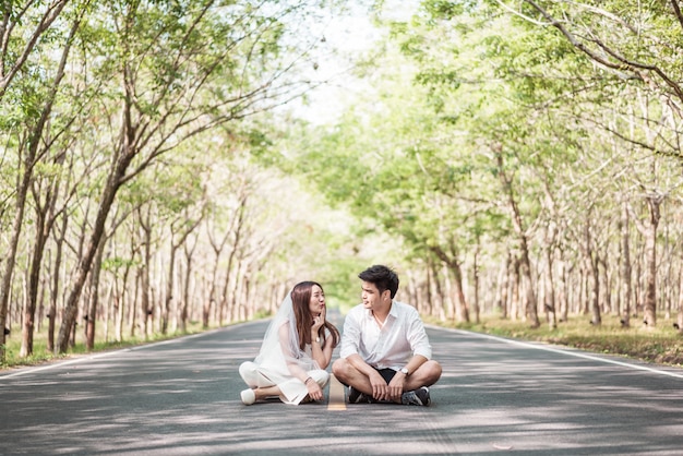 Feliz casal asiático apaixonado na estrada com arco de árvore