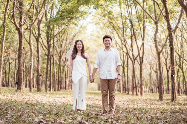 Feliz casal asiático apaixonado por arco de árvore