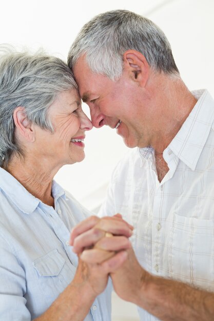 Feliz casal de idosos dançando juntos cabeça a cabeça