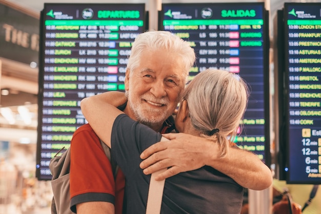 Feliz casal de idosos se abraçando e se despedindo na área do aeroporto para chegar ou partir da viagem