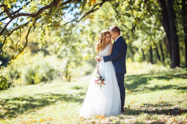 Feliz casal de noivos se diverte no parque O conceito de juventude ama moda e estilo de vida