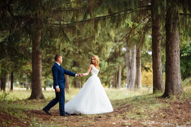 Feliz casal de noivos se diverte no parque O conceito de juventude ama moda e estilo de vida