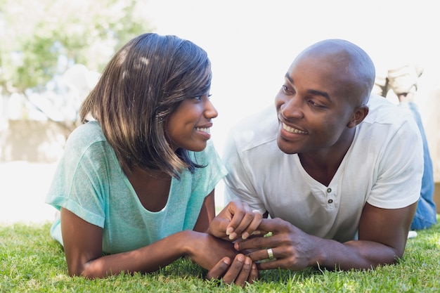 Feliz casal deitado no jardim juntos