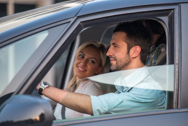 Feliz casal dirigindo no automóvel