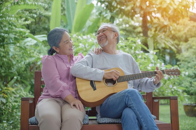 Feliz casal idoso asiático tocando violão enquanto sua esposa cantava juntos ao ar livre em casa, Atividade cuidados de saúde familiar, Aproveitando o estilo de vida durante a aposentadoria se divertindo com os idosos