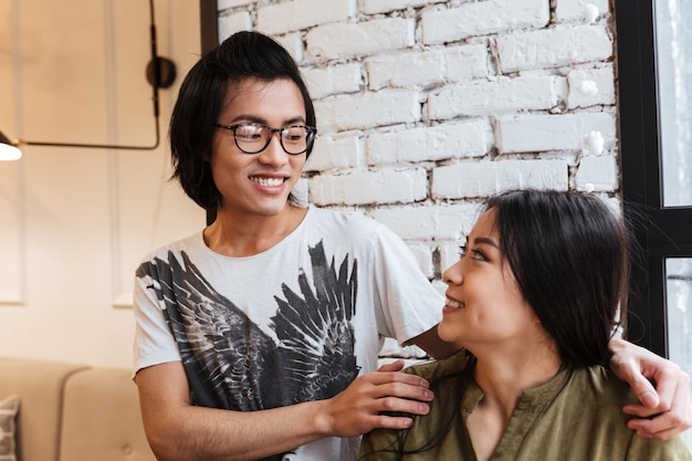 Feliz casal jovem asiático sentado no café