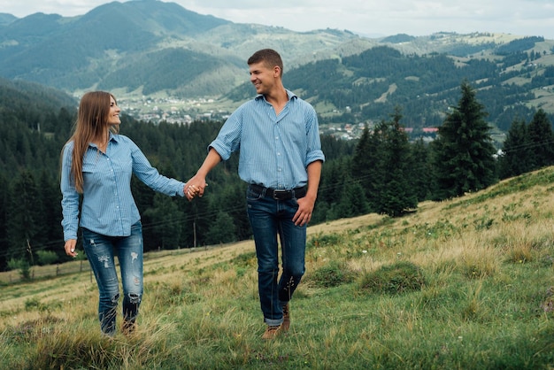 feliz casal jovem caminhando na montanha