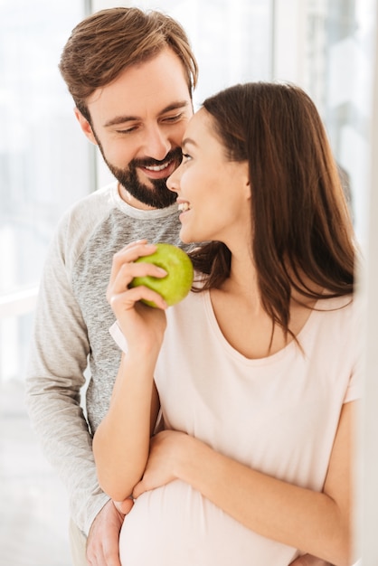 Feliz casal jovem grávida abraçando