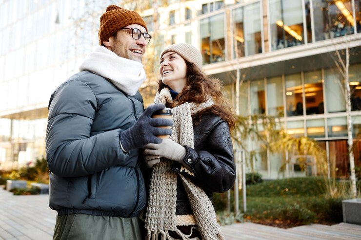Foto feliz casal jovem tomando café e conversando durante sua caminhada na cidade