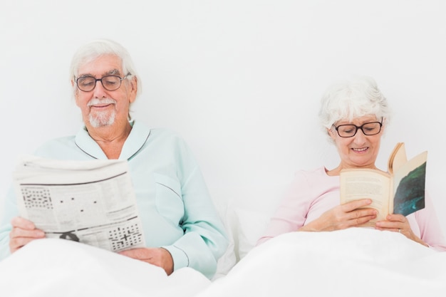 Feliz casal lendo na cama