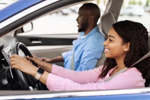 Feliz casal negro desfrutando de uma longa viagem em um carro