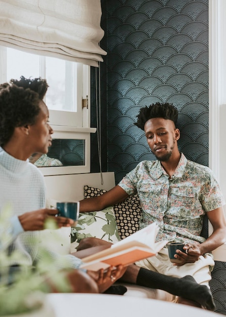 Feliz casal negro lendo um livro em casa