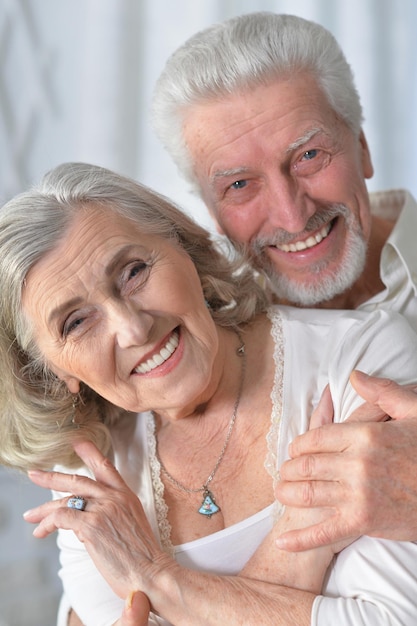 Feliz casal sênior abraçando em casa