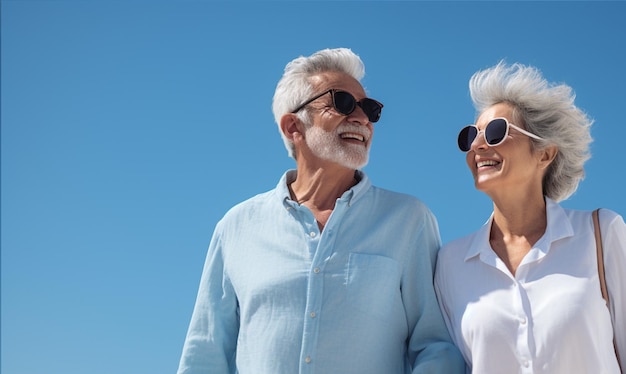 Feliz casal sênior andando e segurando a mão sob o céu azul Conceito de viagem de aposentadoria