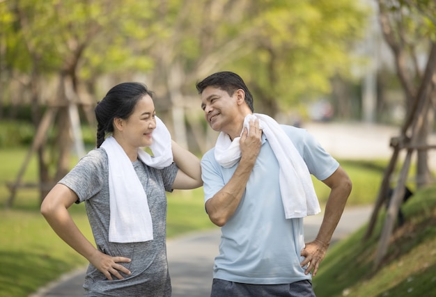 Feliz casal sênior da ásia correndo ao ar livre no parque.